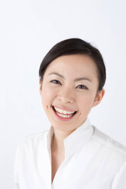 Beyaz arka plan üzerinde gülümseyen genç Asyalı kadın 