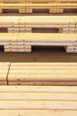 Yığılmış ahşap tahtalar açık alanda sıralar oluşturuyor.