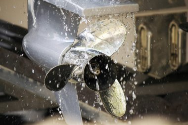 Metal tekne pervanesi su damlacıkları arasında dönüyor.