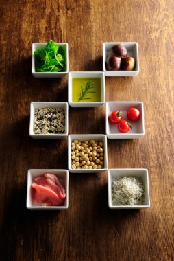 Kare kaselerde çeşitli taze malzemeler var.