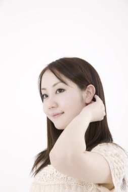 Genç ve güzel Asyalı bir kadının açık arkaplandaki yakın çekimi.