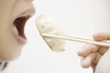 Kadının Japon yemeklerini çubuklarla yerken çekilmiş bir fotoğrafı.