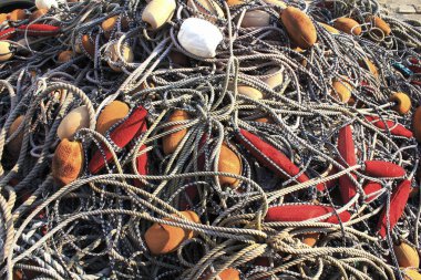 Renkli şamandıralar ve kalın ipler içeren birbirine dolanmış balık ağları