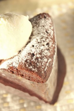 Krem şantili ve pudralı çikolatalı pastanın yakın plan görüntüsü        