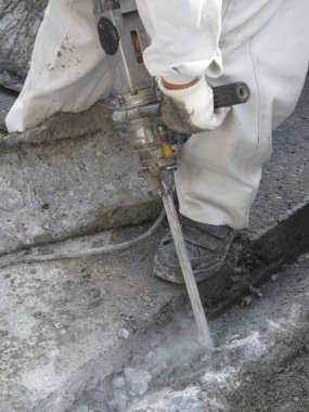 Yol yapımı matkap kullanan işçiler