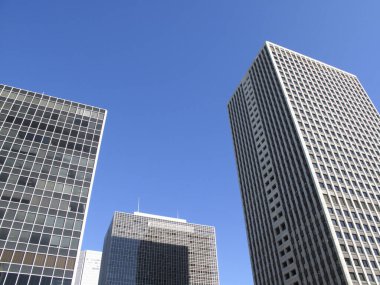 Gökdelenlerin ve binaların alçak açılı görüntüsü mavi gökyüzüne karşı 