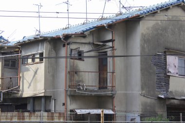 Eski yıpranmış apartman dairesi boyaları ve kırık camları gösteriyor.