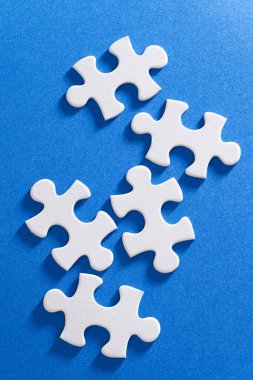 Mavi bir yüzey üzerinde bir grup beyaz yapboz parçası