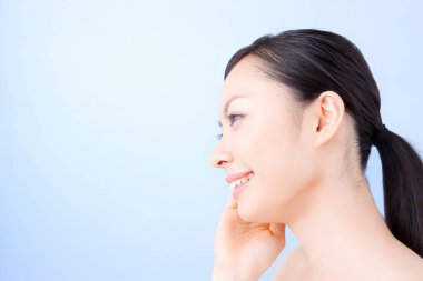 Genç ve güzel Asyalı kadın günlük cilt bakımını yapıyor.