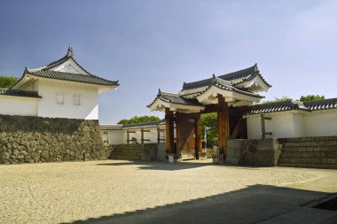 Taş duvarlar ve kapı içeren geleneksel Japon mimarisi.