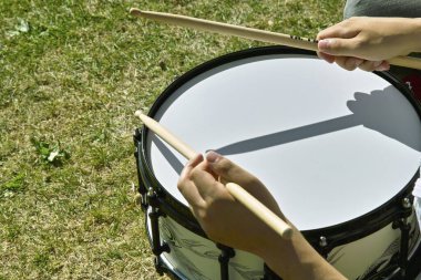 Eller bagetleri açık havada trampetin üstünde tutuyor.