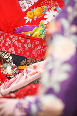 Genç Asyalı kadın geleneksel Japon kostümü giyiyor, orta kısımda.