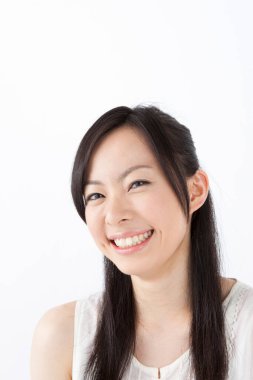 Beyaz arka planda izole edilmiş gülümseyen genç Asyalı kadın. 