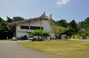 Gökyüzünün altındaki ağaçlarla çevrili modern beton bina