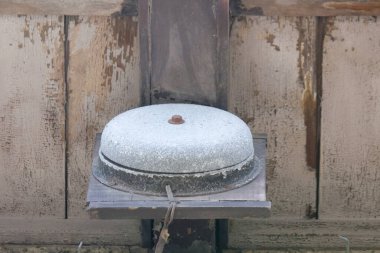 Yıpranmış taş değirmeni ahşap yüzeyde duruyor.