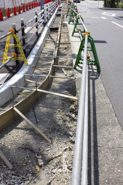 Demiryolu ve bariyerlerin yer aldığı kentsel kaldırım şantiyesi