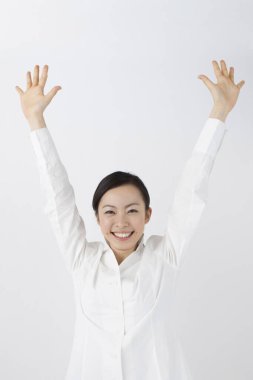 Kolları havada genç bir Asyalı kadının portresi.