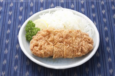 Japon usulü domuz pirzolası (katsu japon yemeği) ve beyaz kase.