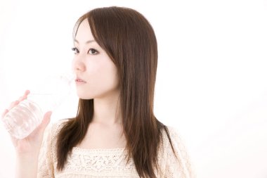 Genç ve güzel Asyalı bir kadının açık arkaplandaki yakın çekimi.