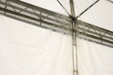 Metal çerçeve beyaz kumaş duvara geometrik gölgeler döküyor