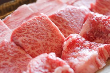 Arka planda taze ve çiğ biftekler, yakın plan.