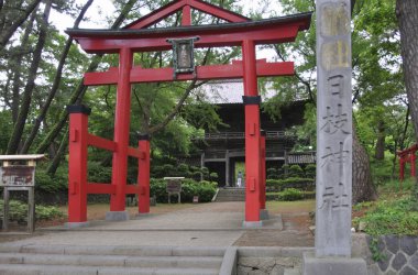 Kırmızı torii kapısı geleneksel Japon türbesi binasına açılıyor.