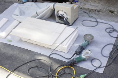 Dışarıdaki elektrikli açı öğütücüleri kullanarak beyaz taş levha kesiyorum.