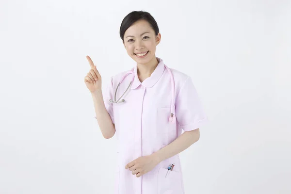 Asiatische Ärztin Uniform Zeigt Auf Etwas Auf Weißem Hintergrund — Stockfoto