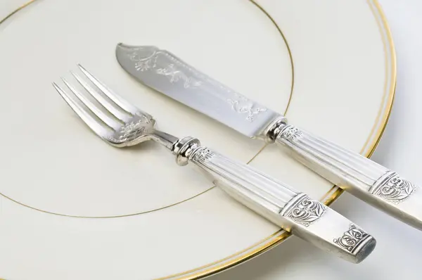 Ασημένιο Πιρούνι Και Μαχαίρι Στο Πιάτο Στο Παρασκήνιο Κοντά — Φωτογραφία Αρχείου