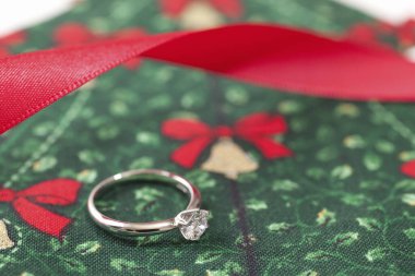 Noel arkaplanında kırmızı kurdeleli alyans      