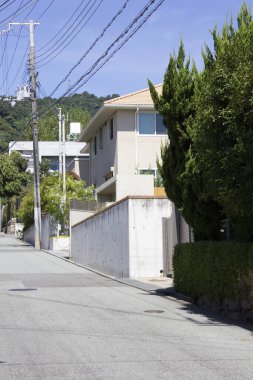 Modern evler ve uzun yeşilliklerin yer aldığı sessiz bir yerleşim yeri.