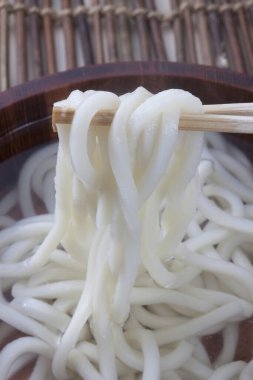 Lezzetli Asya pilavlı eriştenin yemek çubuklarıyla yakın görüntüsü.