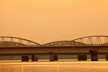 Deniz limanı ve modern köprü üzerinde güzel bir gün batımı.       