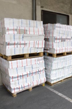 Depoda içi kağıt dolu ahşap paletler.
