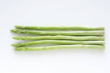 Beyaz arka planda bir sürü kuşkonmaz sebzesi..