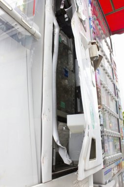 Hasarlı otomat açık kablolar ve kırık paneller gösteriyor