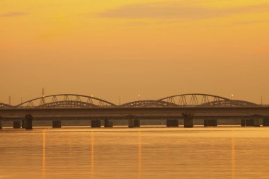 Deniz limanı ve modern köprü üzerinde güzel bir gün batımı.       