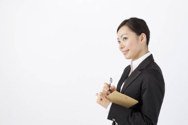 İş kadını elinde not defteri tutuyor.