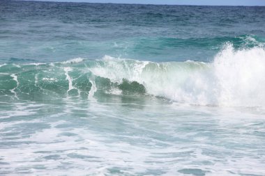 Sahile vuran köpüklü deniz dalgaları. 