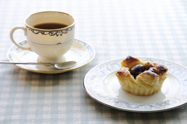 Bir fincan kahve ve masada kek.