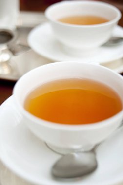 Çayı beyaz bardaklarda masanın üstüne koy.