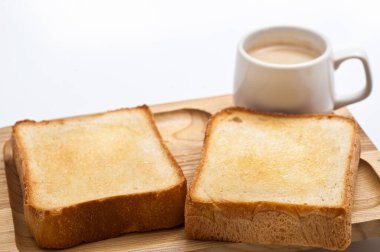 Arka planda tereyağlı ve kahveli taze ekmek.