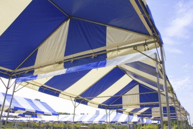 Çadırları ve mavi gökyüzü olan metal yapı