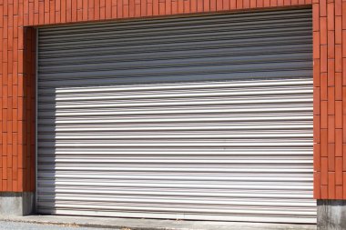 Kapalı metal kepenk kapısı binanın duvarında.