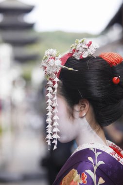 Genç Asyalı kadın geleneksel Japon kostümü ve makyajı giyiyor.