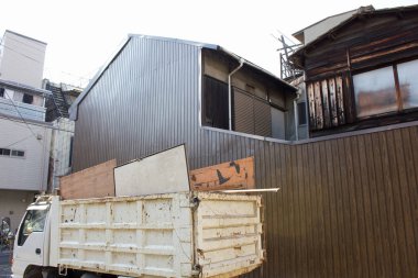 Modern metal binanın yanına park edilmiş beyaz çöp kamyonu.