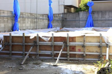 İnşaat alanındaki beton temeli çevreleyen ahşap iskelet