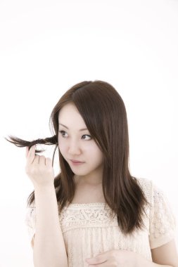 Genç ve güzel Asyalı bir kadının açık arkaplandaki yakın çekimi.