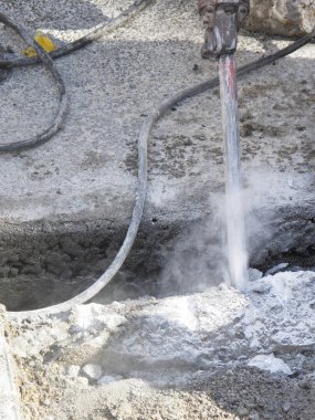 Beton karıştırıcı ve çekiçli bir inşaat alanı.