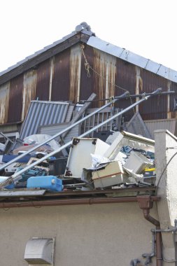 Eski binanın çatısını kaplayan yığınla alet ve metal döküntüsü.